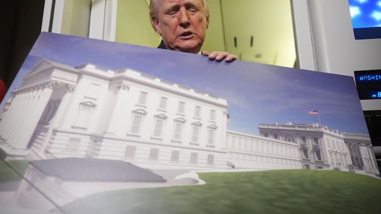 President Donald Trump holds a rendering of the proposed new East Wing of the White House