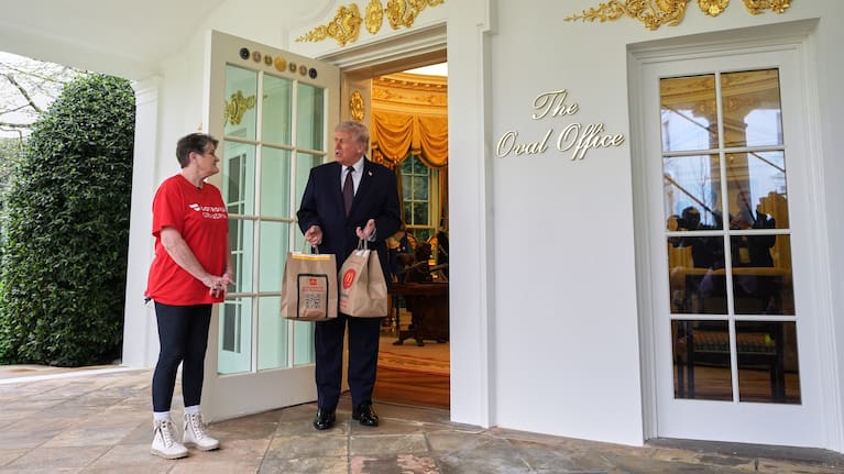 President Donald Trump speaks to Sharon Simmons, a Dasher from Arkansas, who delivered him two bags of McDonald's food outside the Oval Office.