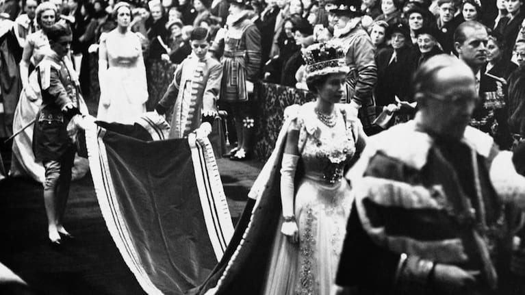 Queen Elizabeth II, wearing the imperial crown, walks through Royal gallery to the House of Lords chamber to officiate the opening of a new session of British Parliament in London, November 30, 1954.