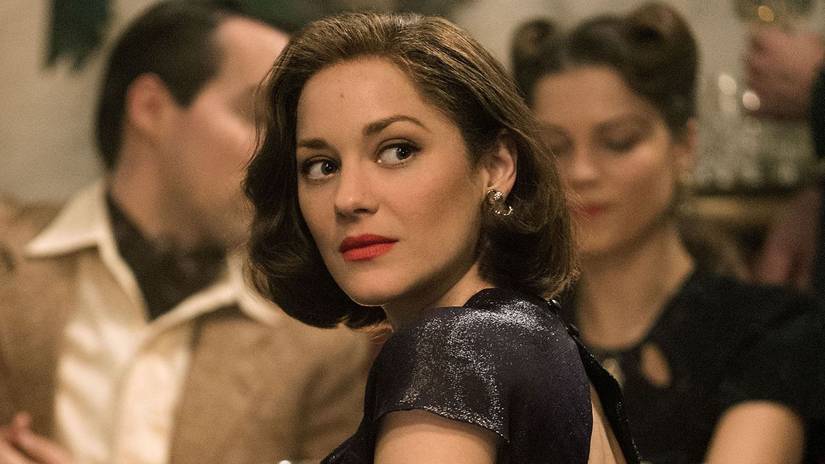 A brunette woman at a crowded event looking back at the viewer