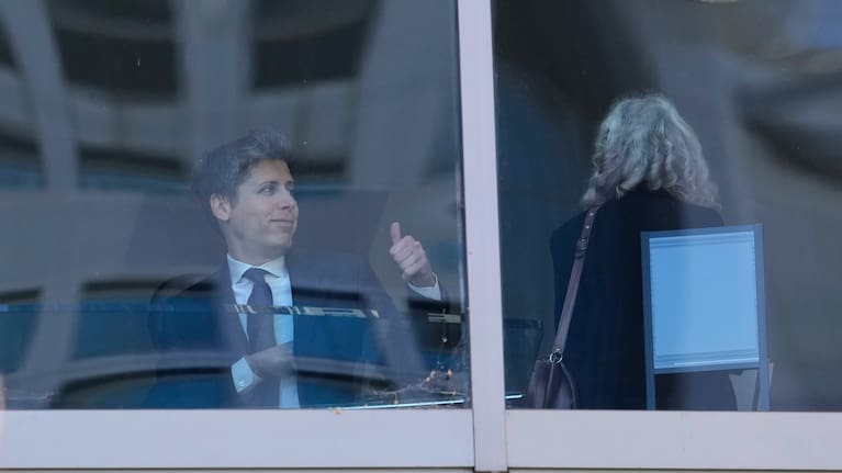 Sam Altman, left, gestures as he walks through a hallway inside the US District Court in Oakland, California.