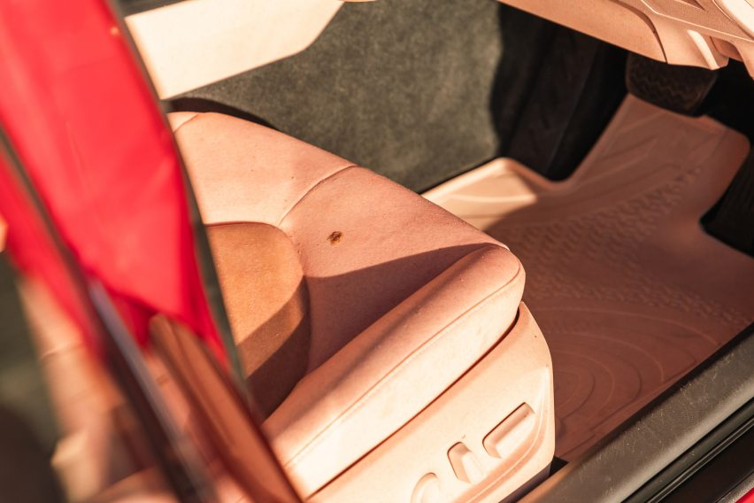 Close-up photo of a seat inside The Sunburnt Car, showing it neatly upholstered in two tones of human-like 
