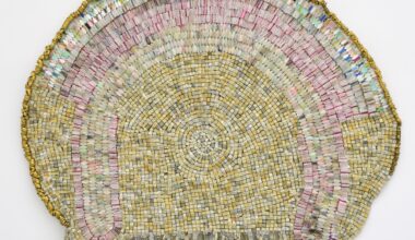 an abstract wall-installed artwork by Moffatt Takadiwa made from computer keyboard keys, combs, toothbrush heads, and metal pieces