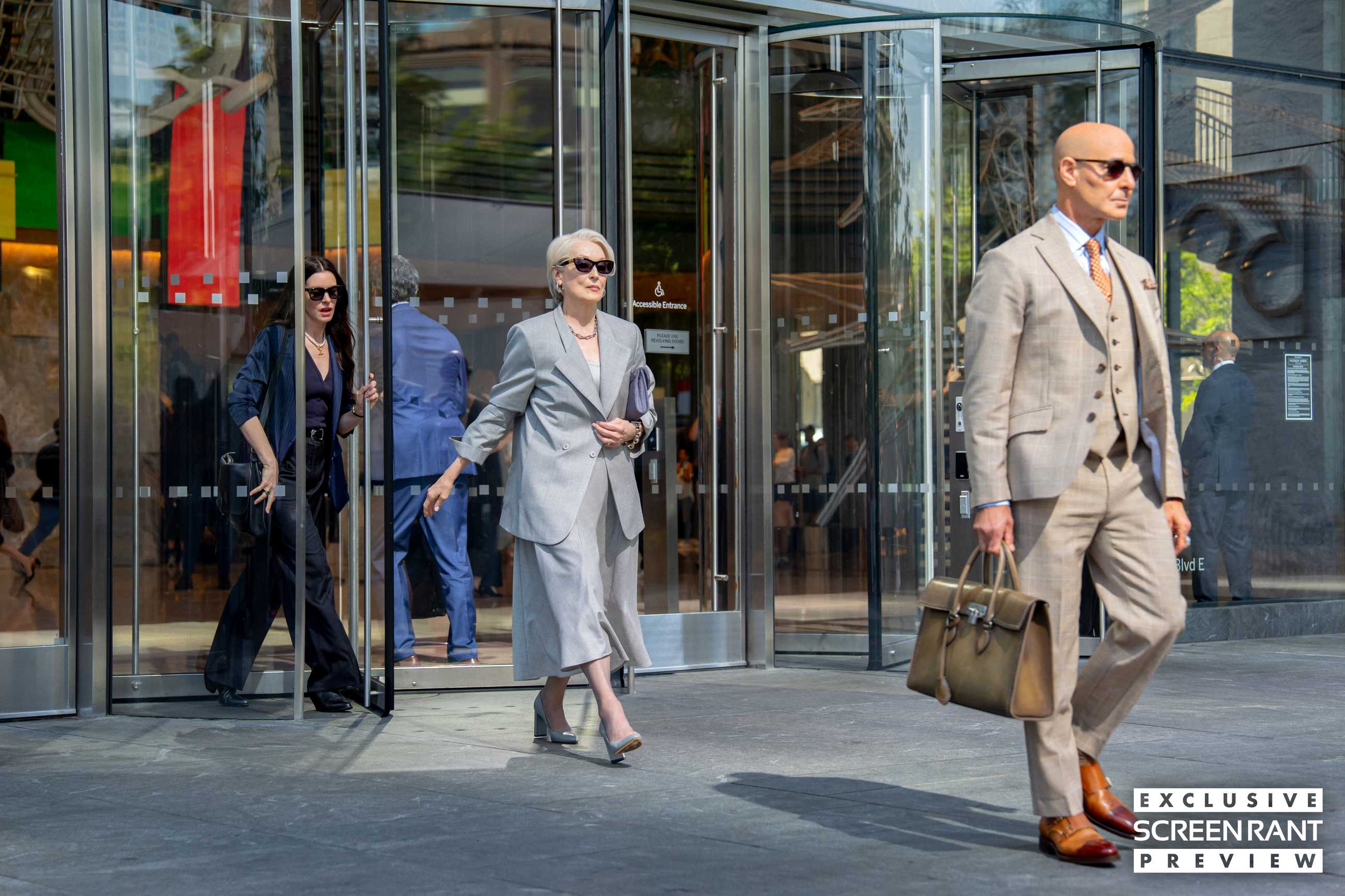Stanley Tucci, Meryl Streep and Anne Hathaway exit a building in The Devil Wears Prada 2