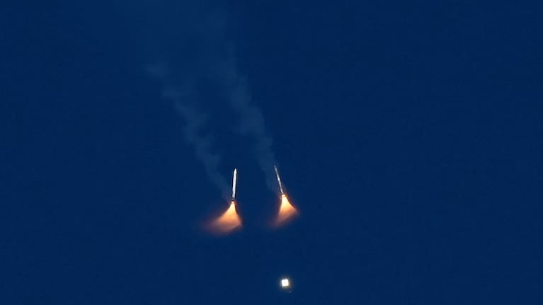 The solid rocket boosters on NASA's Artemis II moon rocket fall away after lifting off from the Kennedy Space Center's Launch Pad 39-B