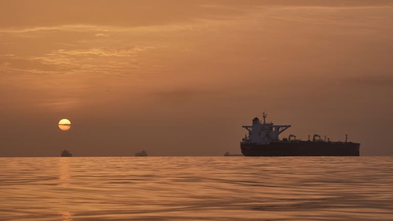 The sun rises behind tankers anchored in the Strait of Hormuz off the coast of Qeshm Island, Iran, Saturday, April 18, 2026.