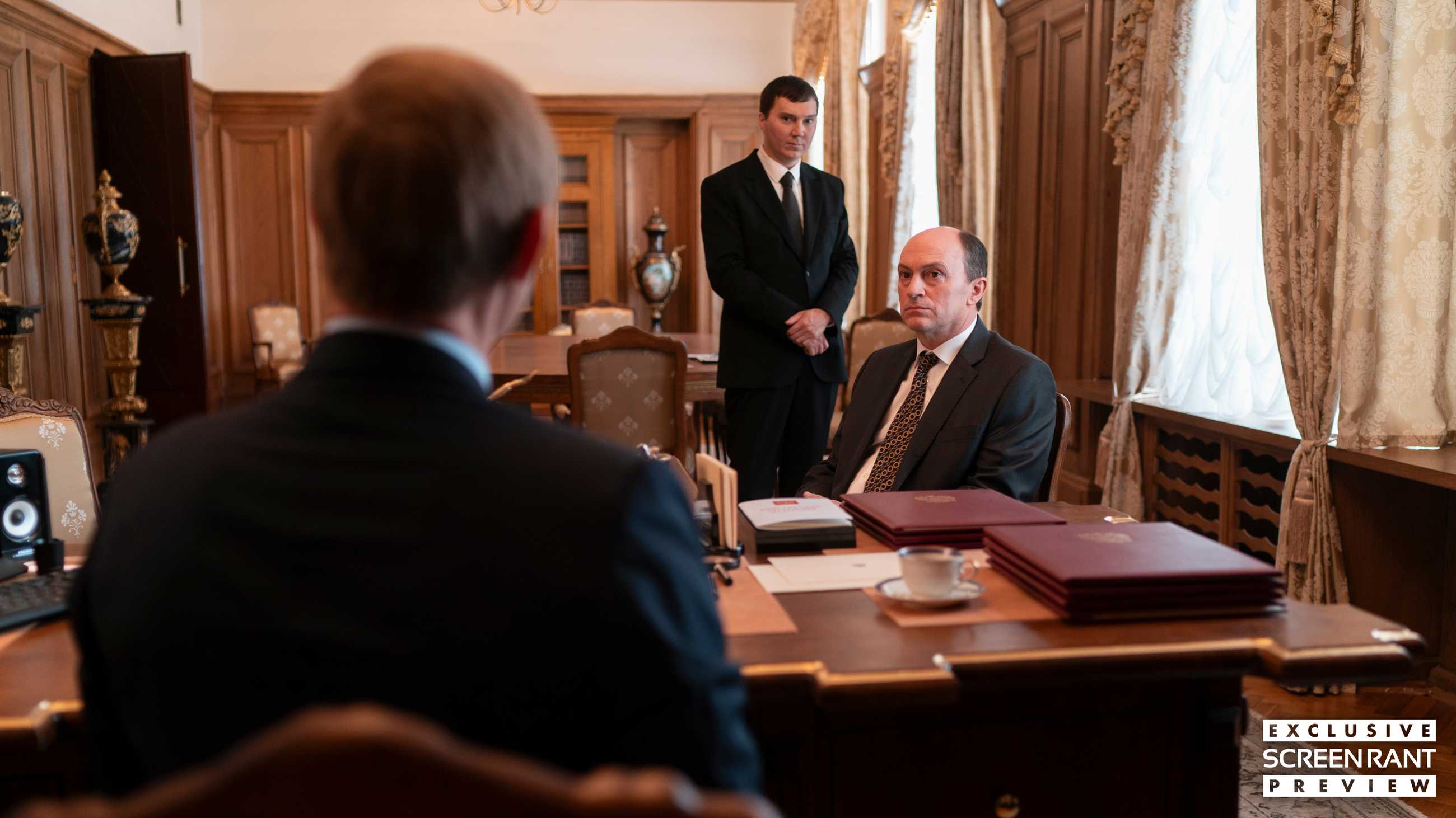 Paul Dano and Will Keen staring at Jude Law seen from behind in The Wizard of the Kremlin