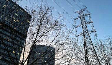Electric transmission tower rises over high-rise buildings at dusk in Istanbul, Türkiye. (Adobe Stock Photo)