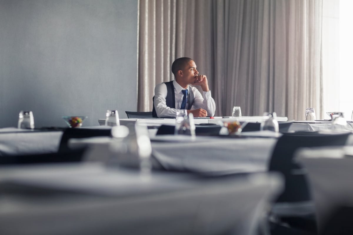 Person sitting at conference table, deep in thought.