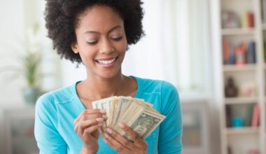 An investor counts money while sitting in a living room.