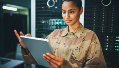 A soldier analyzes data inside a data center.