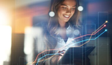 Person smiling and holding a tablet with charts superimposed in front of the picture.