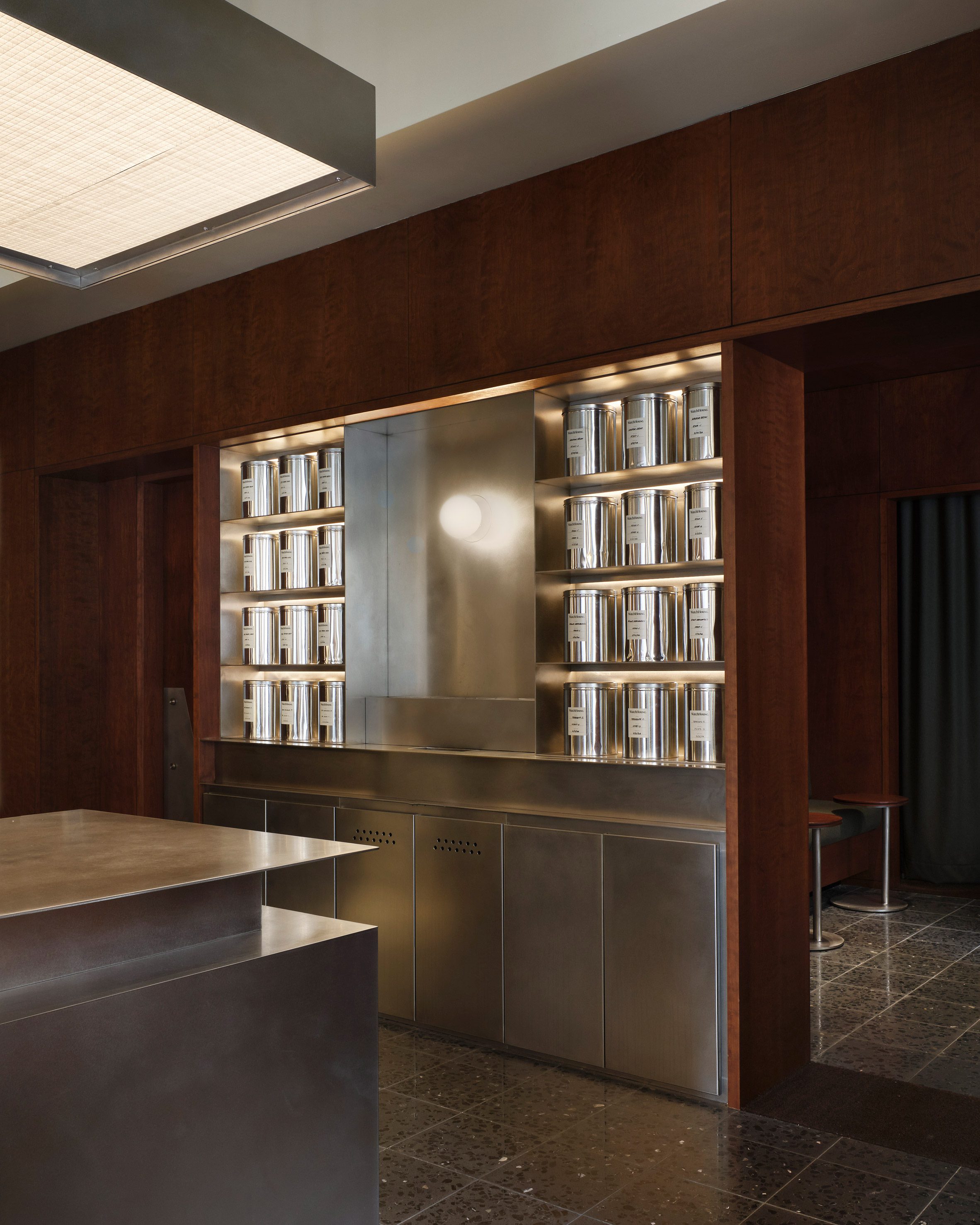 A steel counter and shelving display inset within cherry wood walls