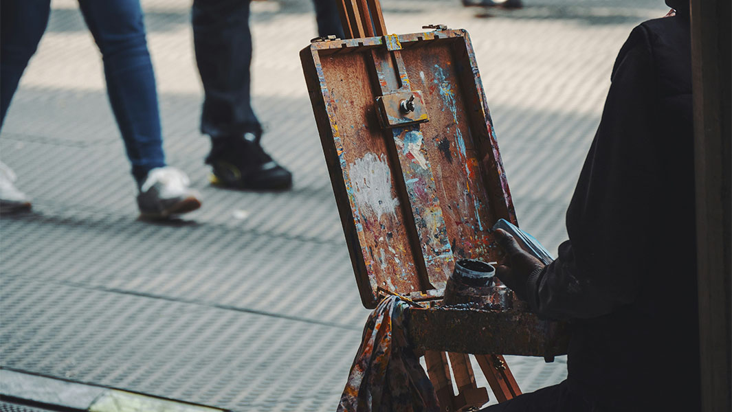 an artist sitting at an easel