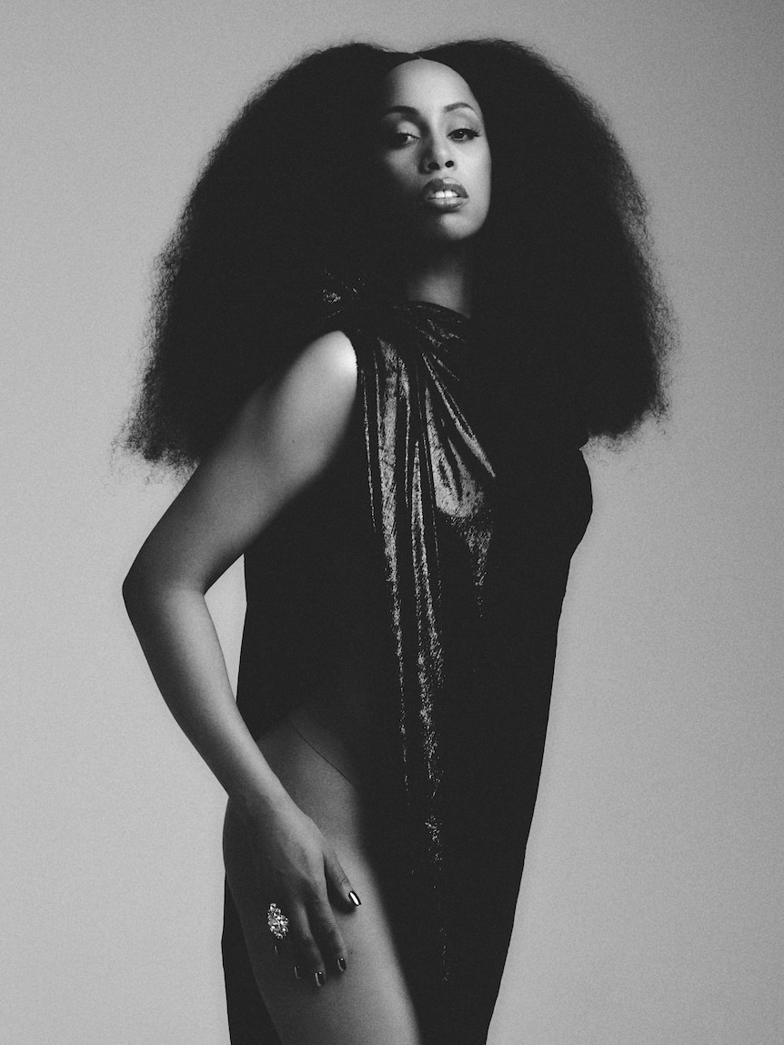 Black-and-white portrait of Rochelle Jordan with voluminous hair and a sleeveless glossy dress.