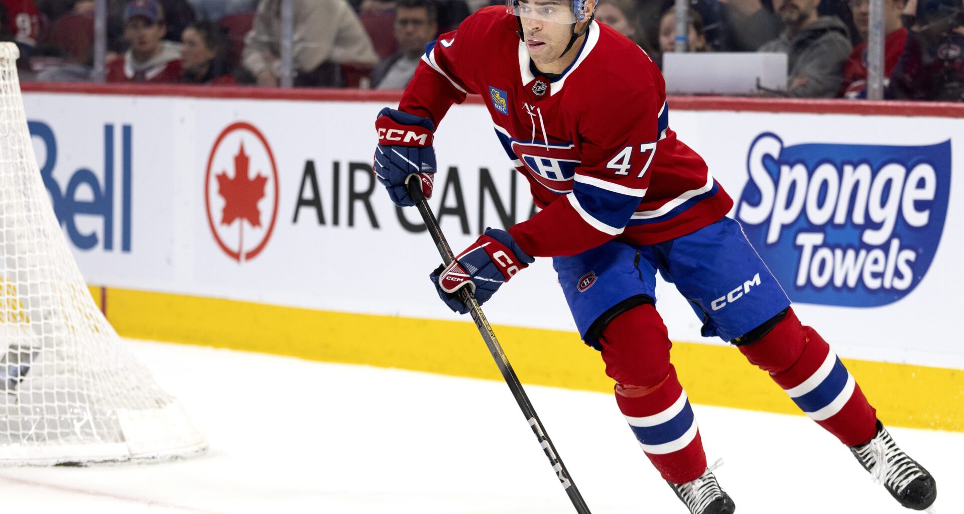 Hockey player with the puck behind the new.