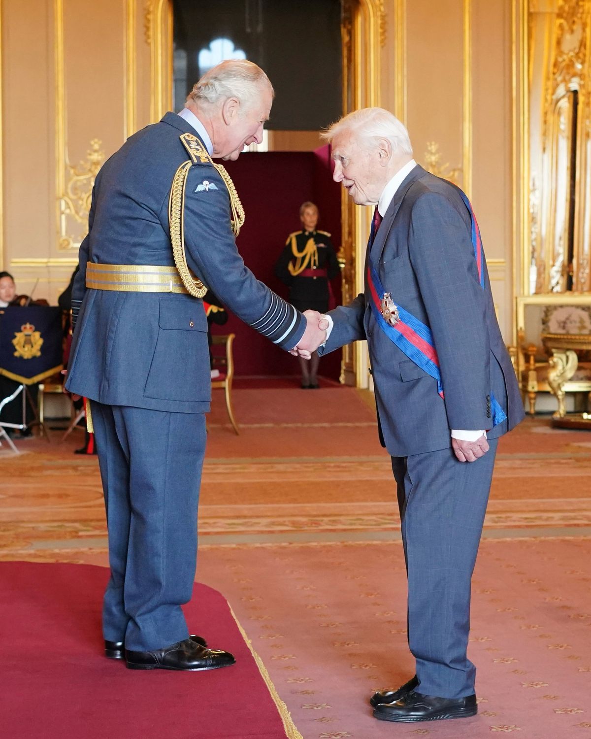 King Charles presenting Sir David Attenborough with his knighthood at Buckingham Palace