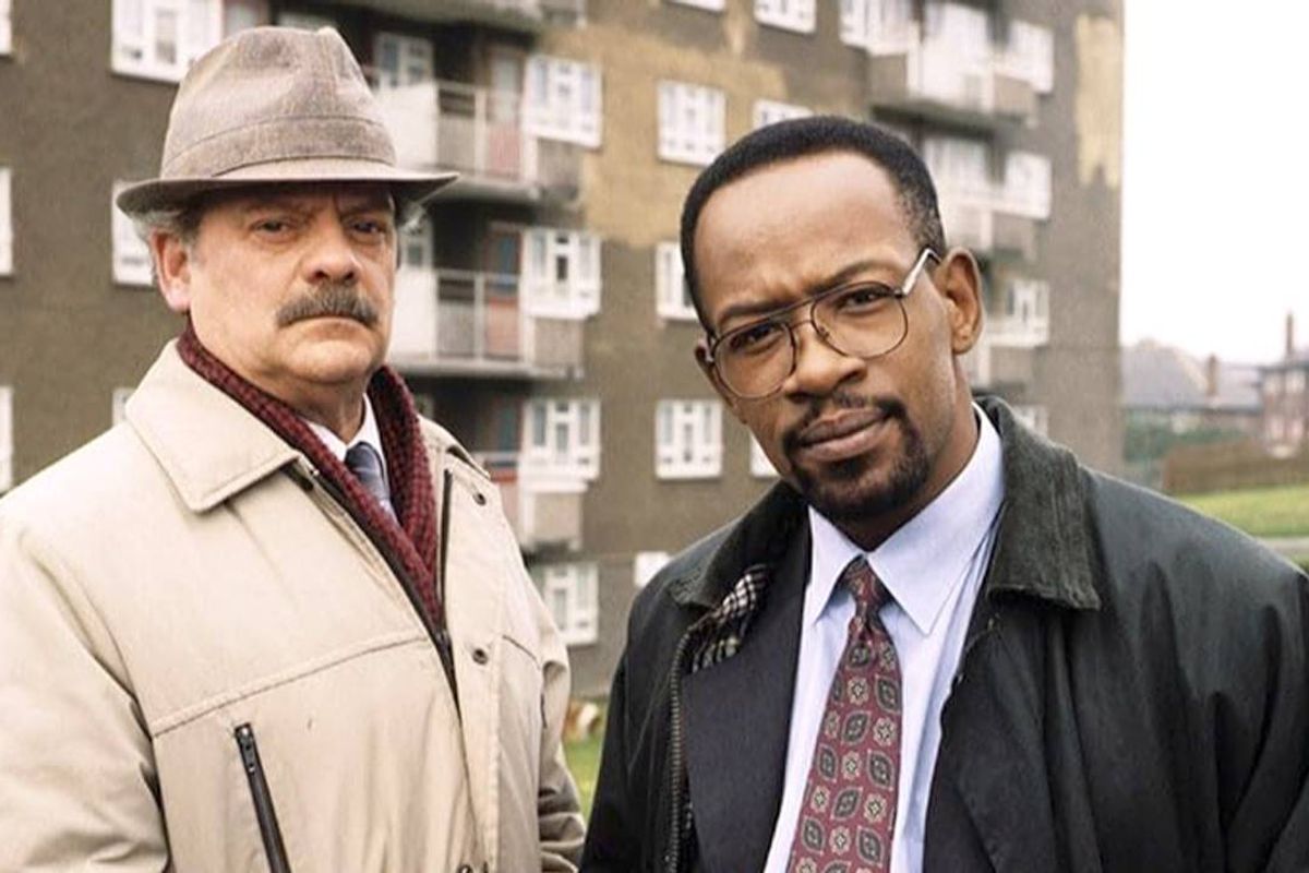 Two men stand and look serious outside a flats