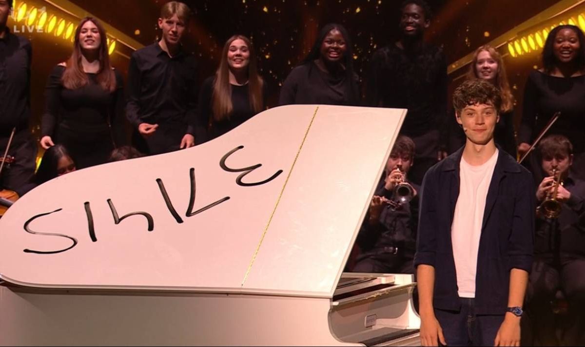 Teenager standing next to a piano