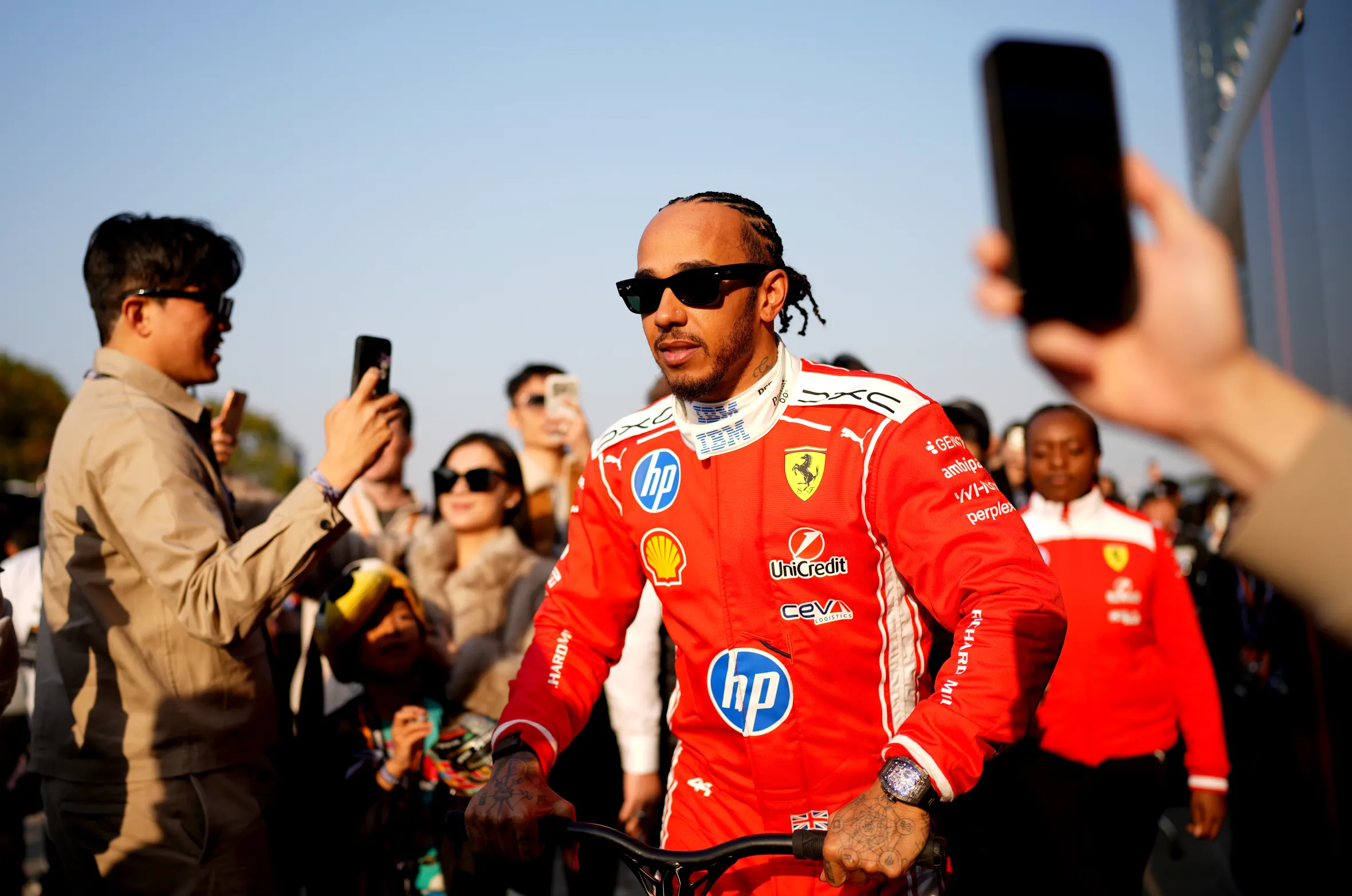 Fourth placed qualifier Lewis Hamilton of Great Britain wearing a red racing suit and black sunglasses during Sprint qualifying.