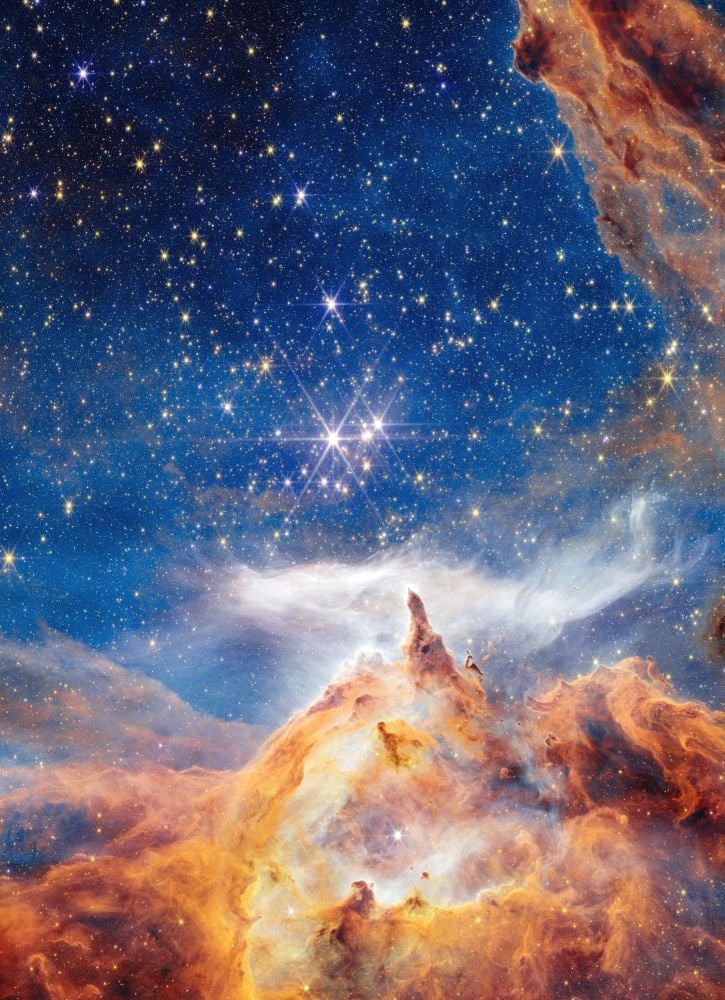 An extended gaseous finger points to the Pismis 24 open star cluster in this JWST NIRCam image. Stars in a cluster are siblings, having been birthed from the same massive cloud of gas. But clusters themselves can also be siblings arranged in binary pairs, and recent research illuminates their heirarchical nature. Image Credit: NASA, ESA, CSA, STScI; Image Processing: Alyssa Pagan (STScI)
