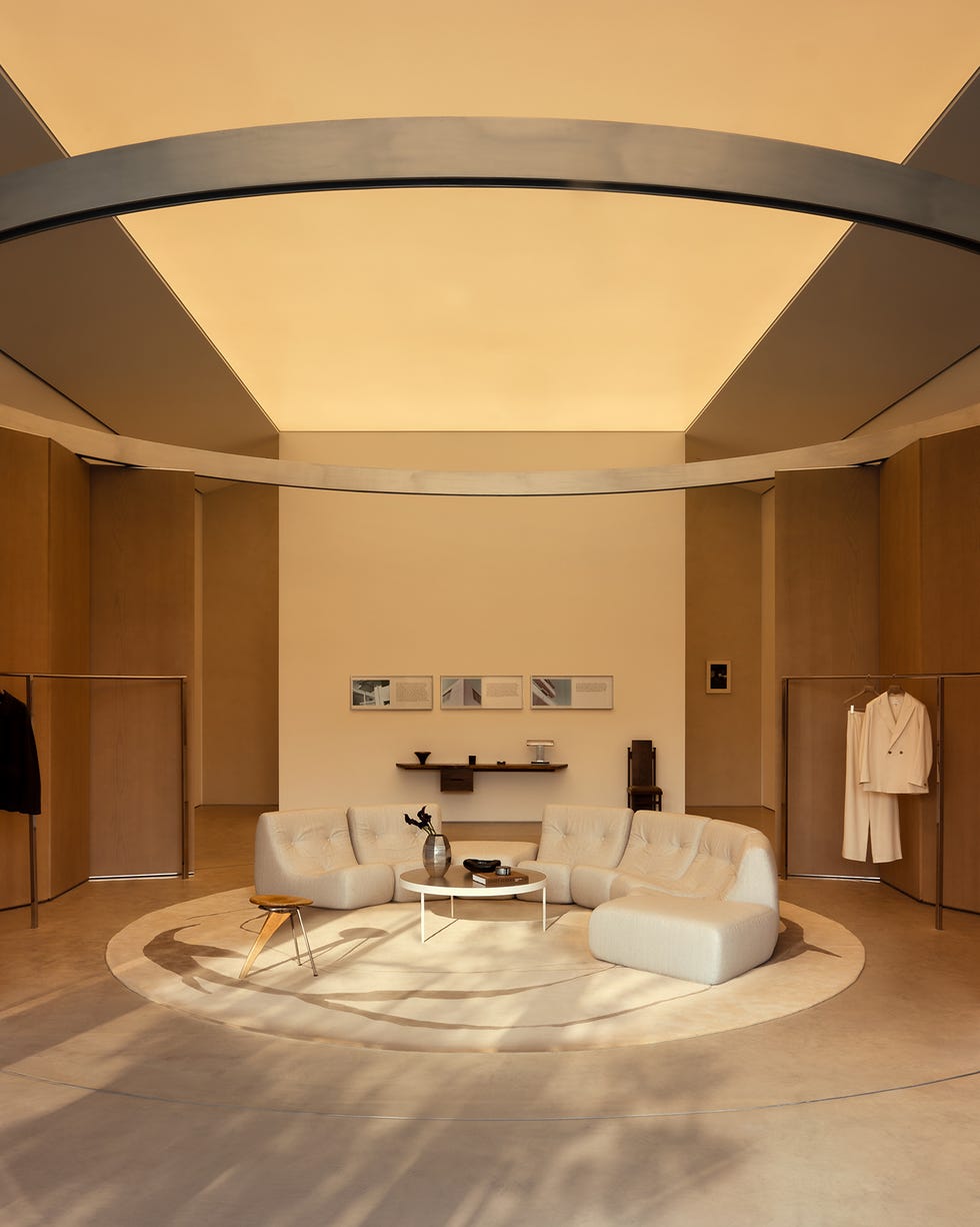 Modern interior space featuring seating and clothing display.