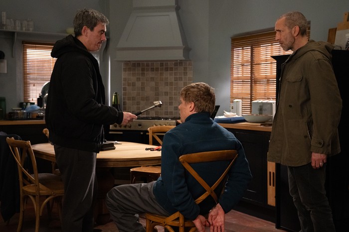 15_05_emm_cain_robert_02 Cain holds a hammer to Robert, who is strapped to a chair as Sam watches on in Emmerdale