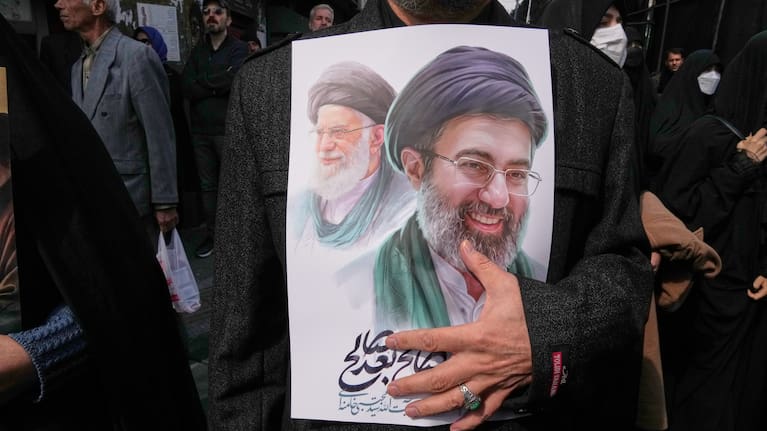 A mourner holds a poster depicting Ayatollah Mojtaba Khamenei