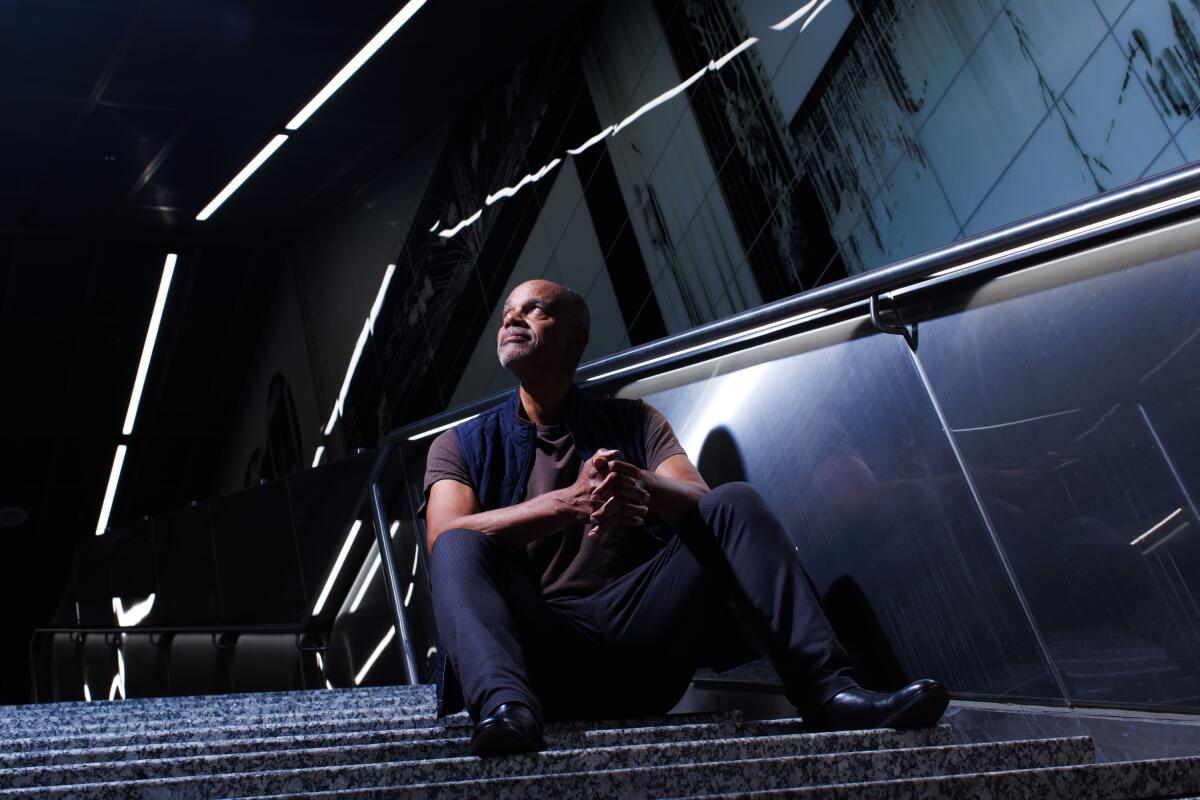 Artist Todd Gray sits in front of his work inside the Wilshire/La Cienega Metro Station