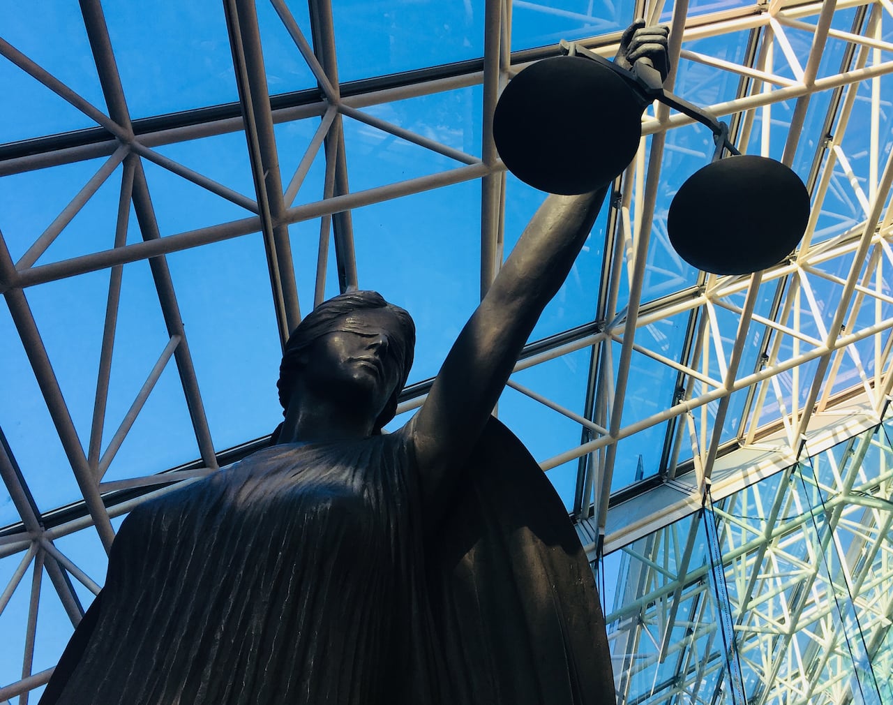 A statue of a blindfolded woman holding a set of scales.