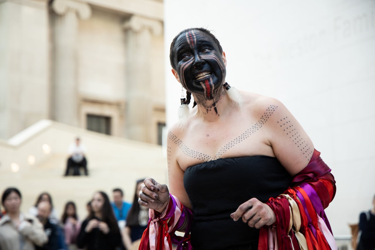 a woman with black facepaint, a black top, and ribbons on her arm
