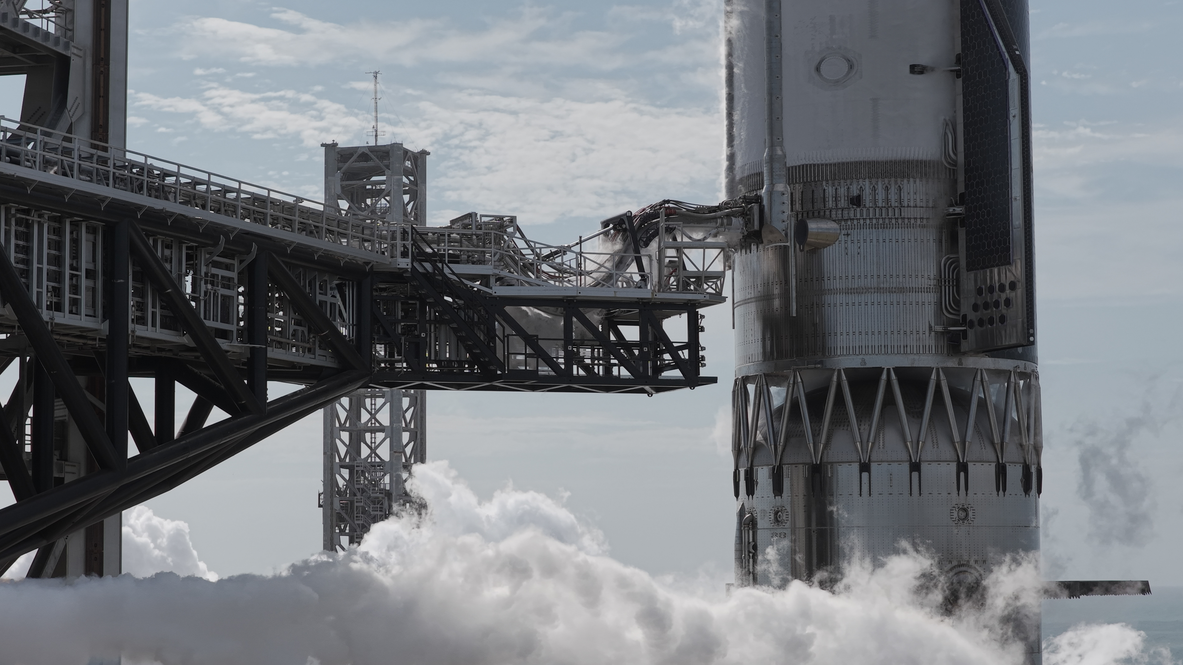 closeup of the middle portion of a silver rocket on the pad
