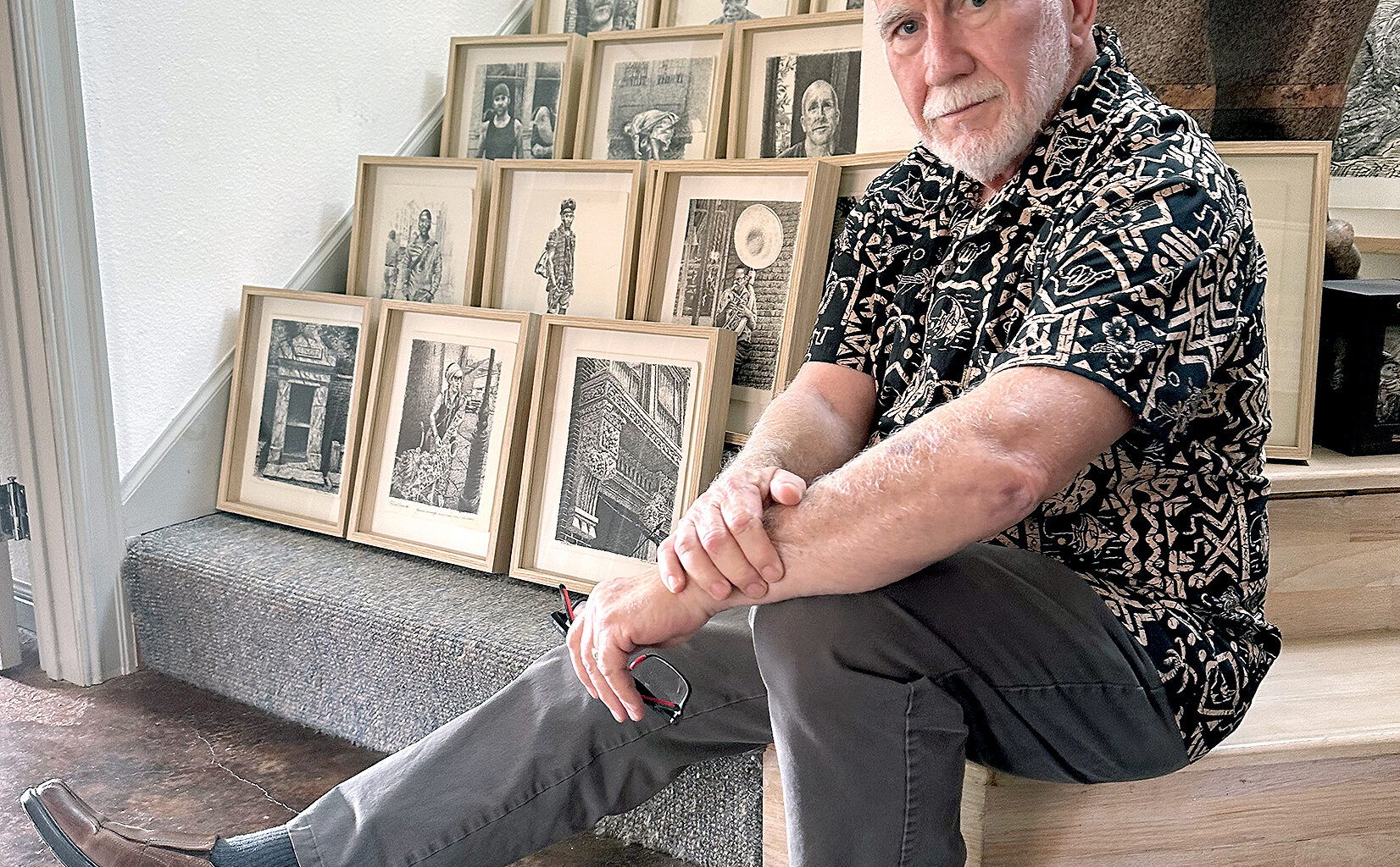 Artist Rob Clark sits with framed pages from his New Orleans sketchbook which will be on display in the exhibition "Extracting the Light" at the Beaumont Art League.