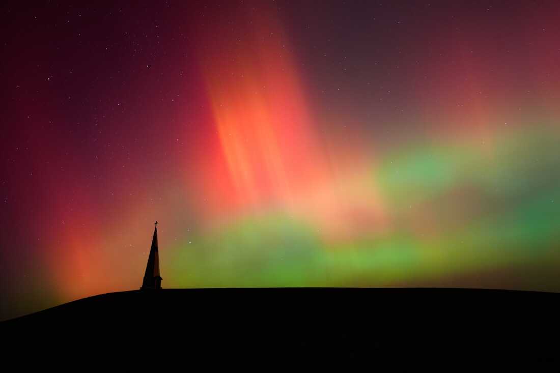 FILE - Northern lights fill the sky behind the Saint Joseph the Woodworker Shrine, near Valley Falls, Kan., Nov. 11, 2025.