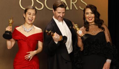 From left, Michelle L.M. Wong, Chris Appelhans and Maggie Kang pose with the award for Best Animated Feature Film for