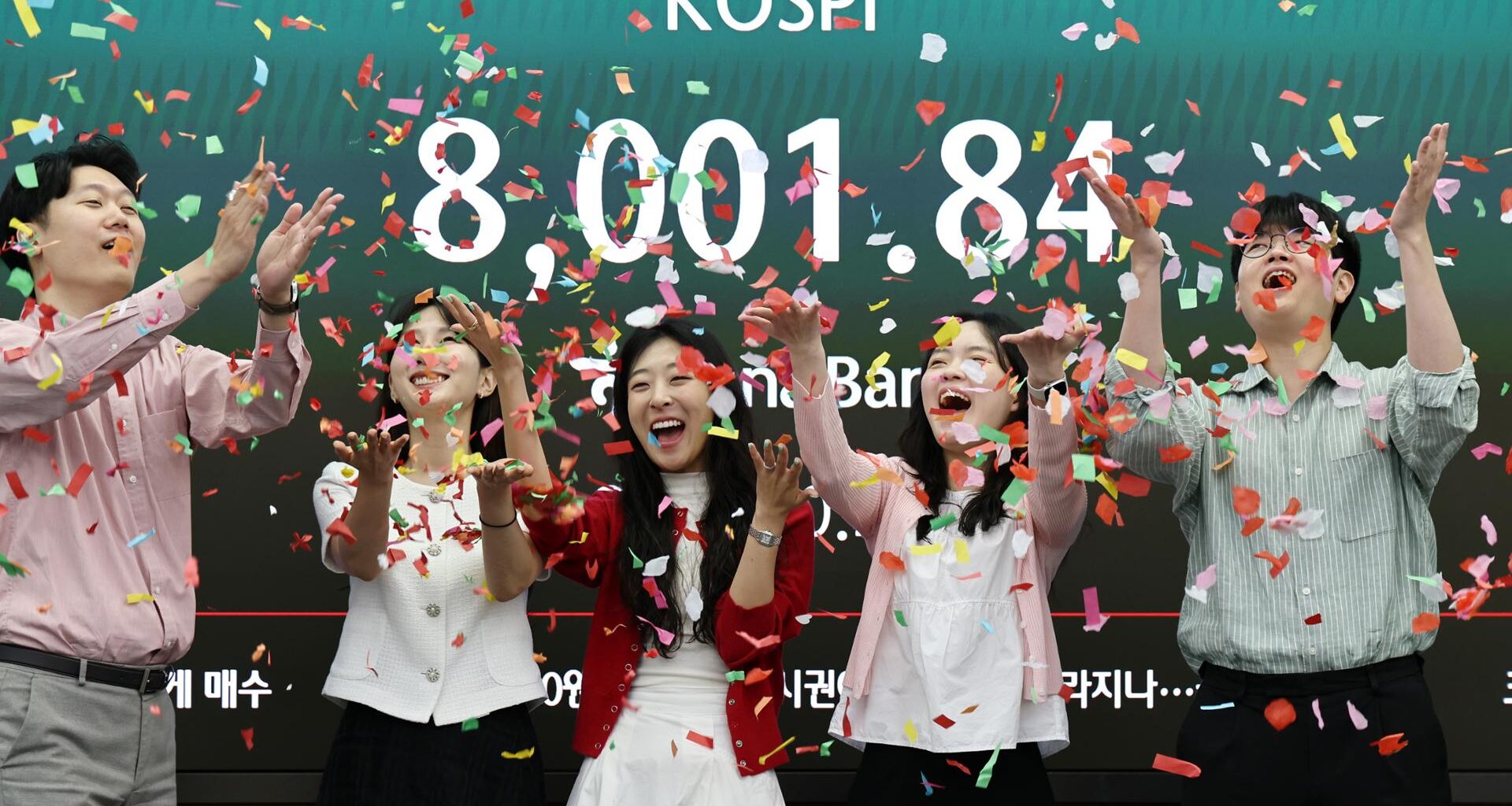 Dealers at Hana Bank headquarters in Seoul celebrate after the benchmark KOSPI crossed the historic 8,000 mark for the first time during intraday trading, May 15. Yonhap