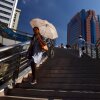 A woman uses an umbrella as a sun shade in August 2013 as she walks on an overpass in Shanghai, which was experiencing its worst heat in 140 years. A new study found that more than 200 heat waves, including the China heatwave, were substantially more likely and more intense because of the activity of major fossil fuel producers.