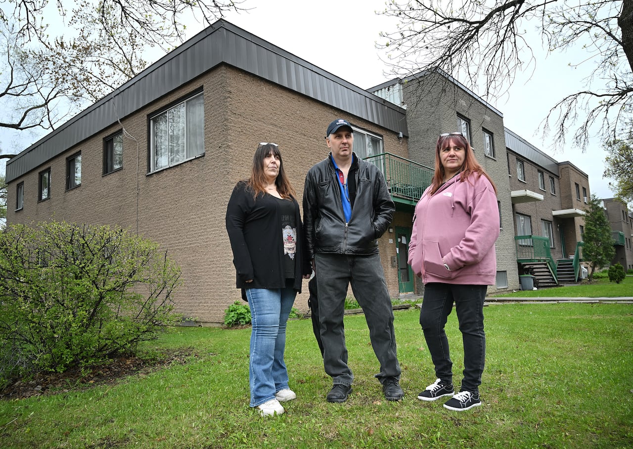 Veronique Perron, from left, Richard Marchand and Sophie Racine pose outside their homes in Montreal, on Wednesday, May 13, 2026. The building is part of a social housing complex.