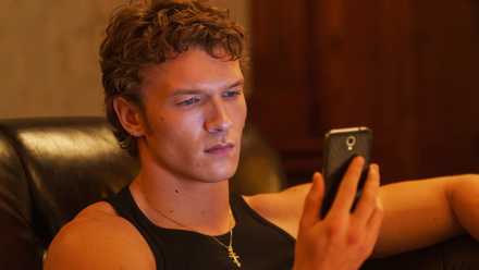 Connor Storrie's Ilya looking at his phone in Episode 5 of Heated Rivalry