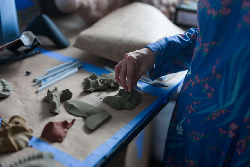 Yi is photographed with fossil prototypes made for her Storm King installation “Message from the Mud.”