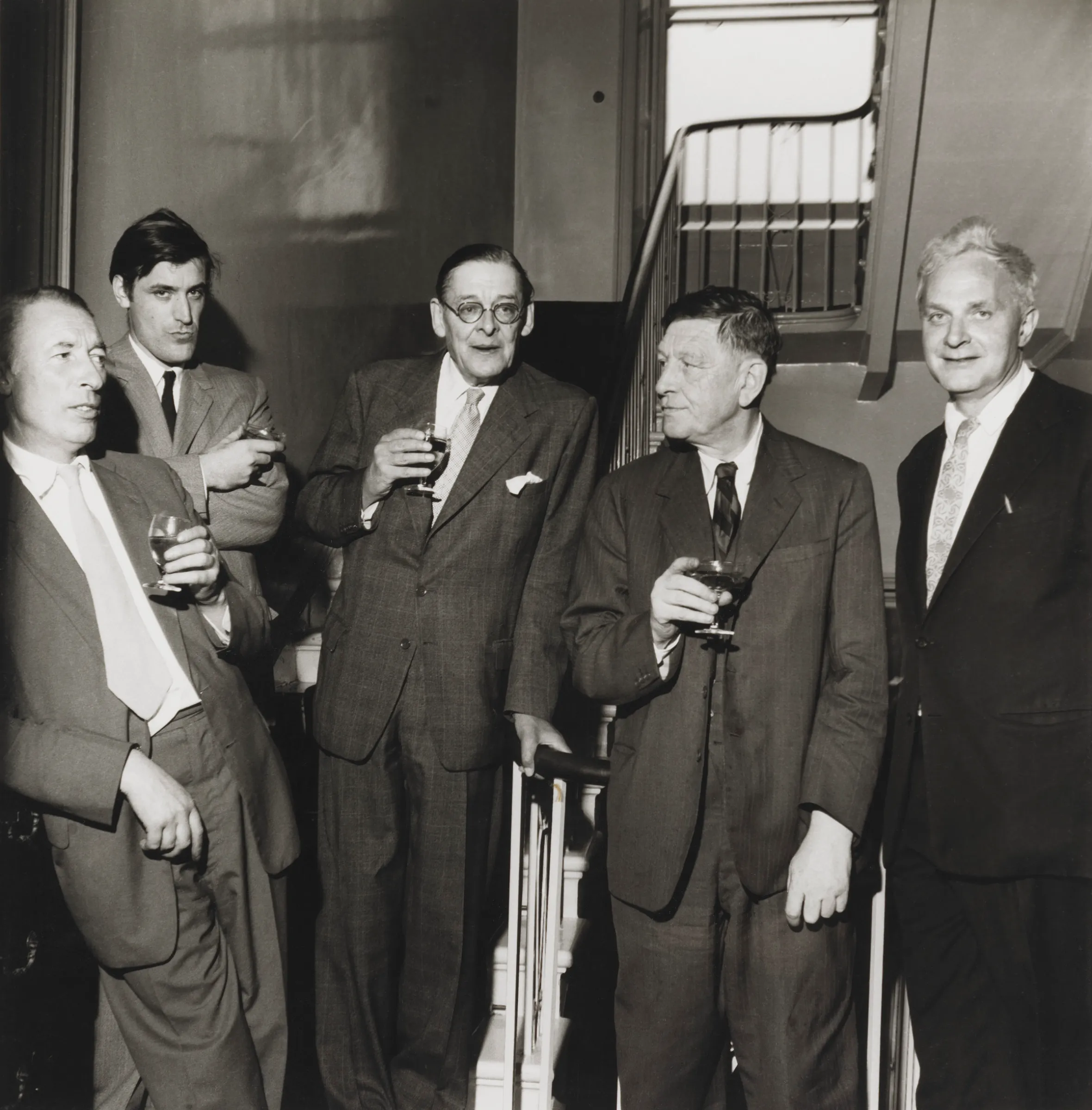 Five Faber poets (Louis MacNeice, Ted Hughes, T.S. Eliot, W.H. Auden, and Stephen Spender) socializing.
