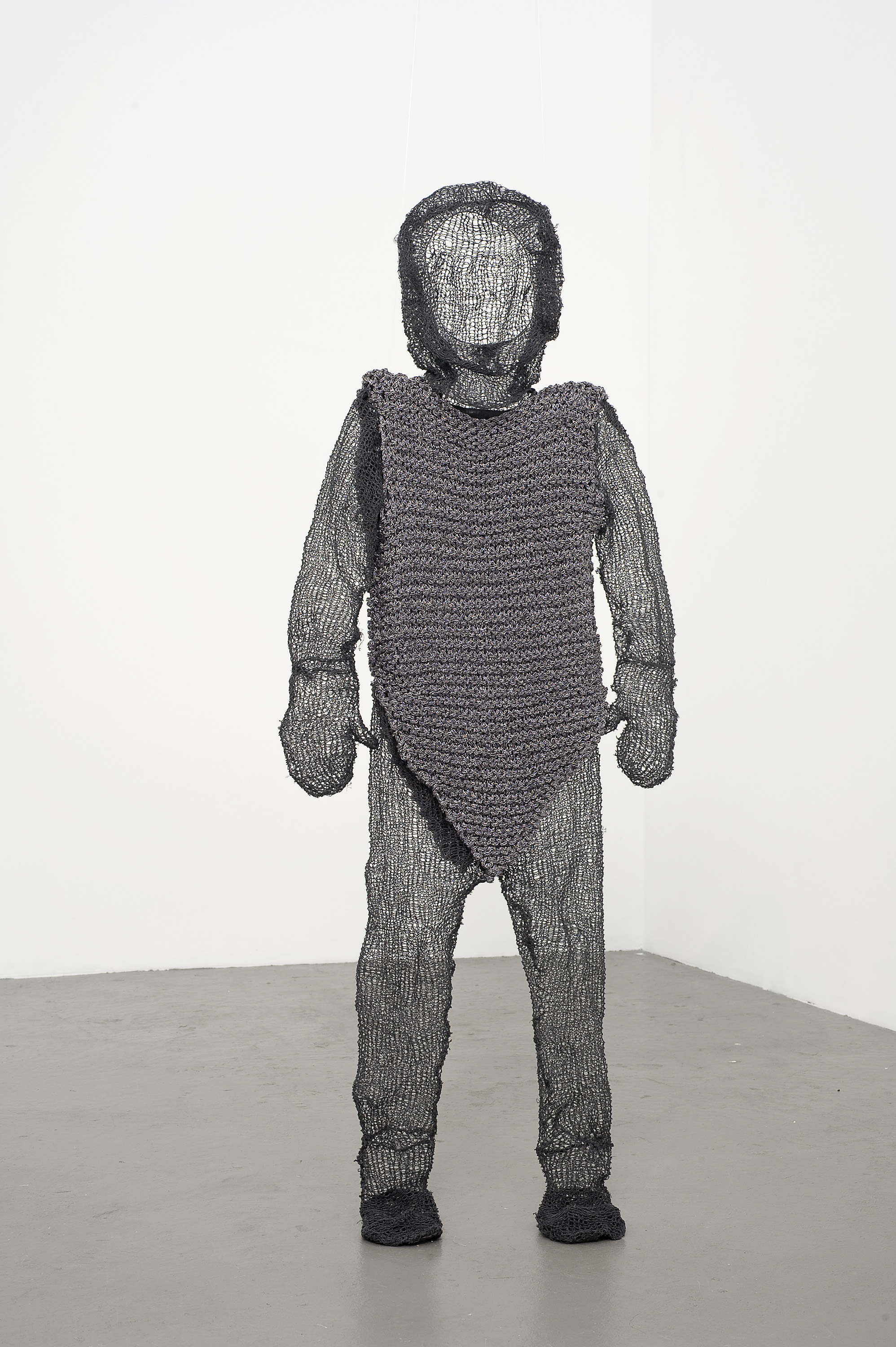 A child-sized knitted chain mail suit of armour with hood.