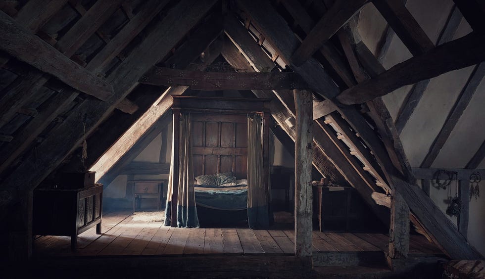 attic space with a bed and wooden furniture