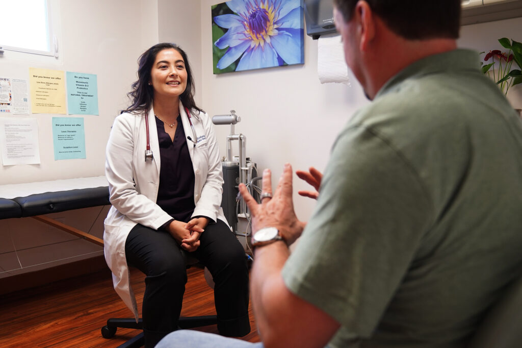 Dr. Krishanna Takemoto-Gentile talks with patient Andres Harnisch in the clinic Thursday, Jan. 29, 2026, in Honolulu. (Kevin Fujii/Civil Beat/2026)