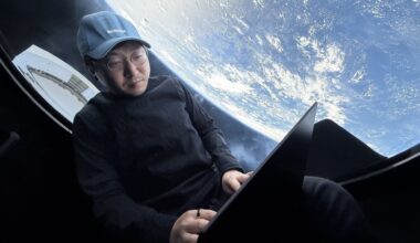 Mission commander Chun Wang works on his laptop with Earth looming outside the window of SpaceX's Dragon capsule during the Fram2 mission in 2025. (Chun Wang / SpaceX via X)
