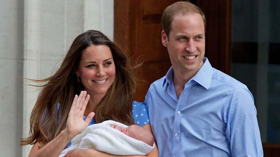 Prince William and Catherine, Princess of Wales (waving) introduce Prince George to the world's media, standing on the steps outside the Lindo Wing of St Mary's Hospital in London on July 23, 2013