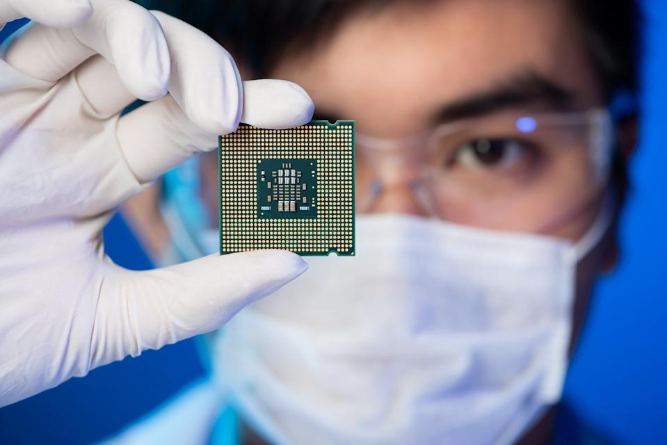 An engineer holding a CPU inside of a chip lab.