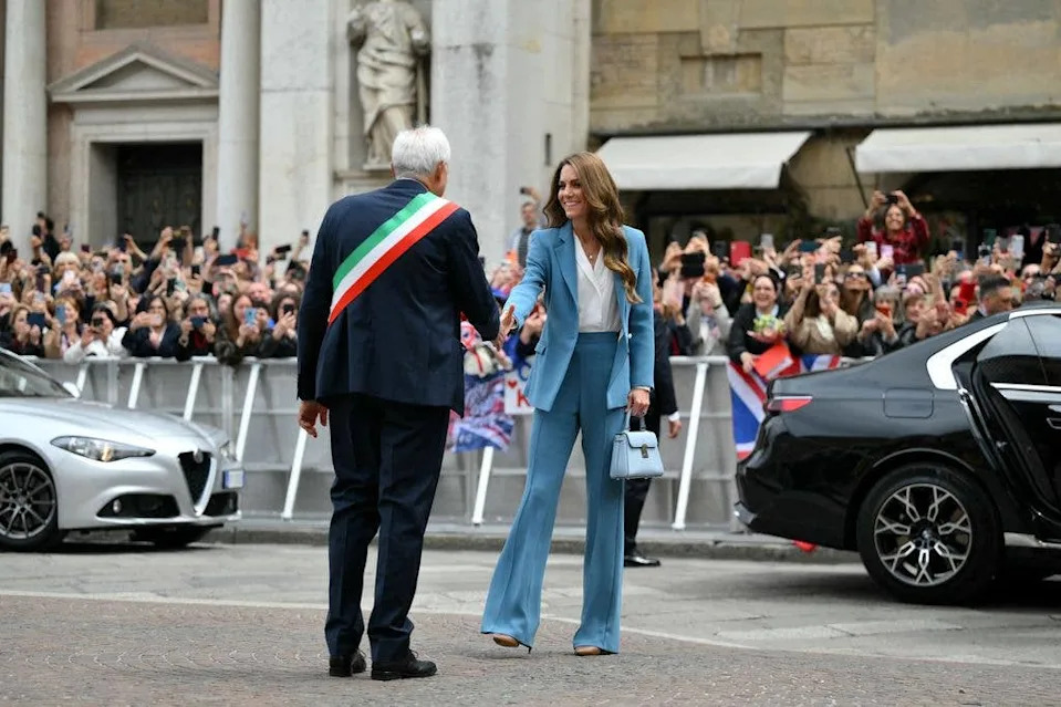 Britain's Catherine, Princess of Wales is welcomed by the mayor of Reggio Emilia, Marco Massari with a handshake