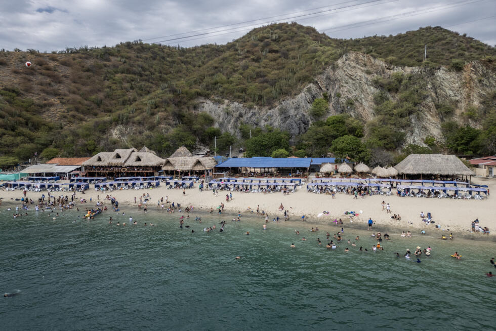 Aerial view of Playa Blanca beach in the Colombian region of Santa Marta, where mountains sweep down through jungle to the Caribbean