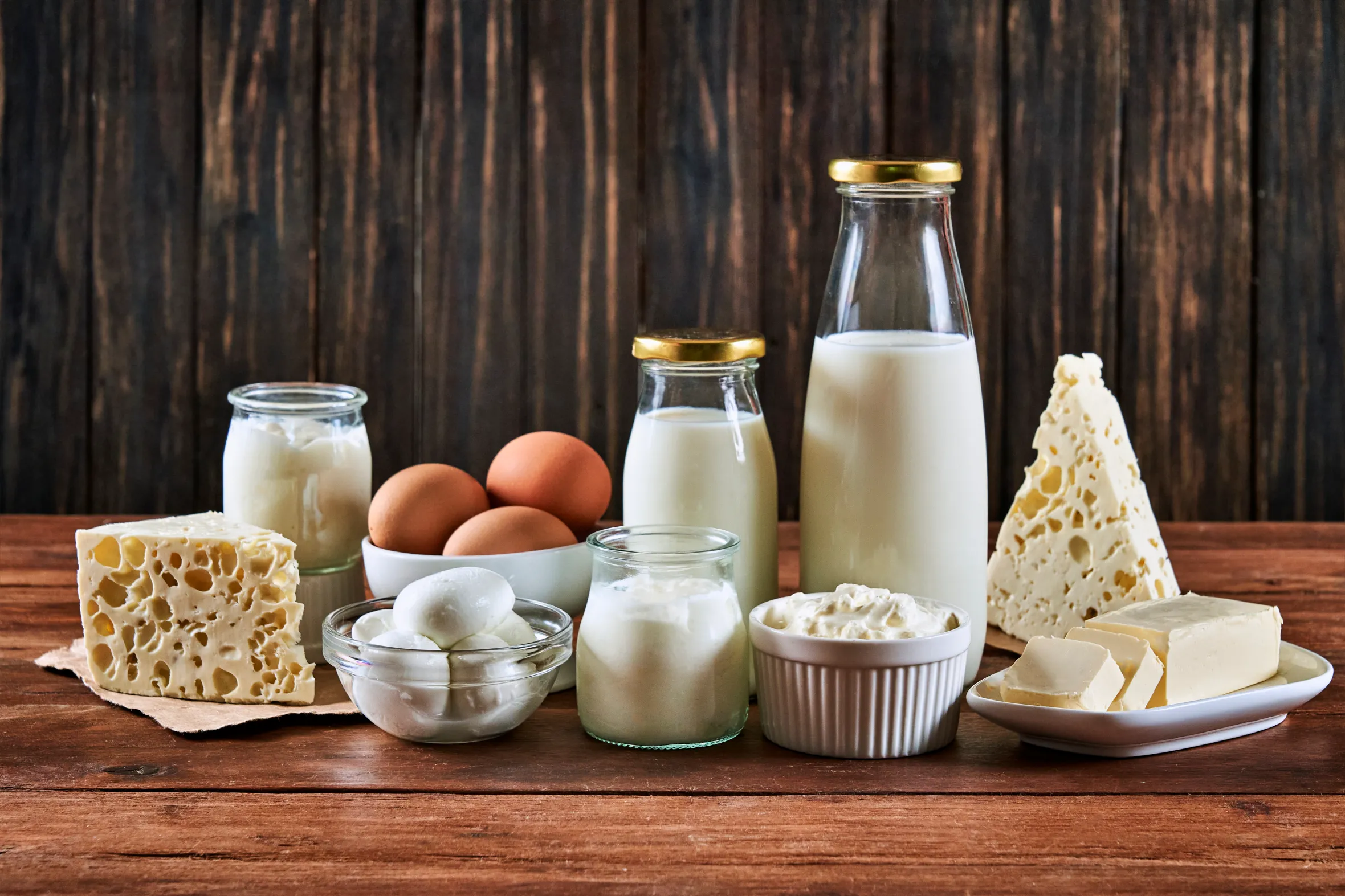 An assortment of dairy products on a rustic wooden table.